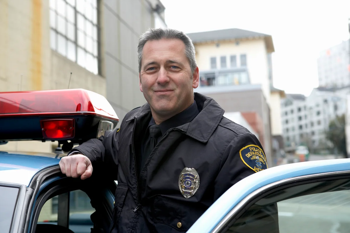 Police officer standing by patrol car
