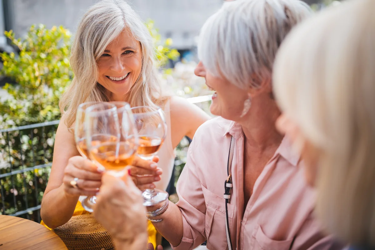 mother tasting wine with friends and family