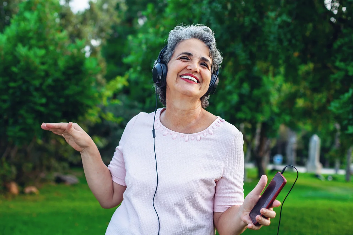 Senior woman listening music with headphones