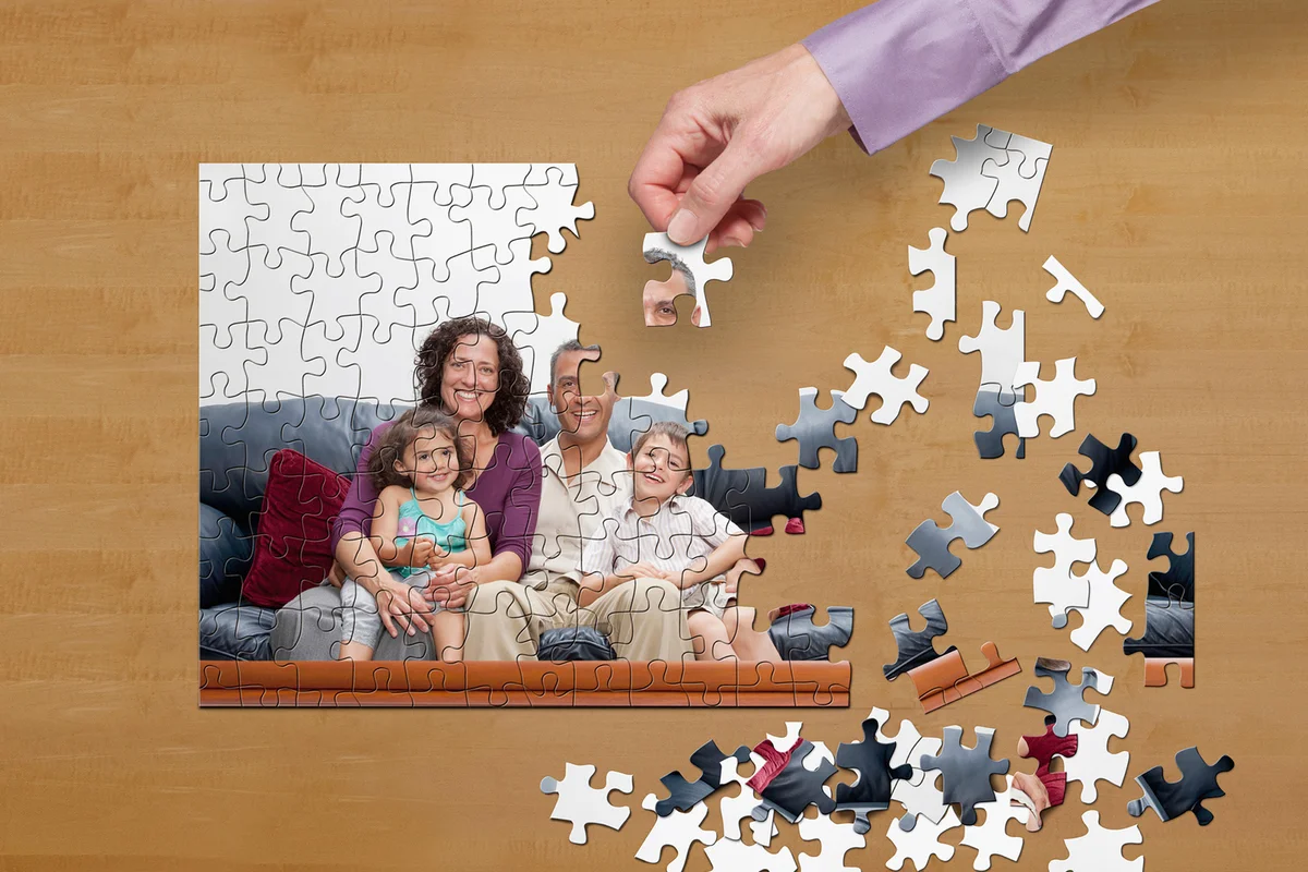 Man putting puzzle together on desk