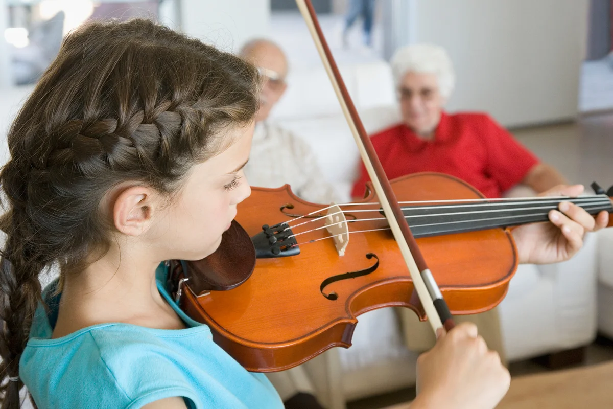 Girl playing violin for grandparents
