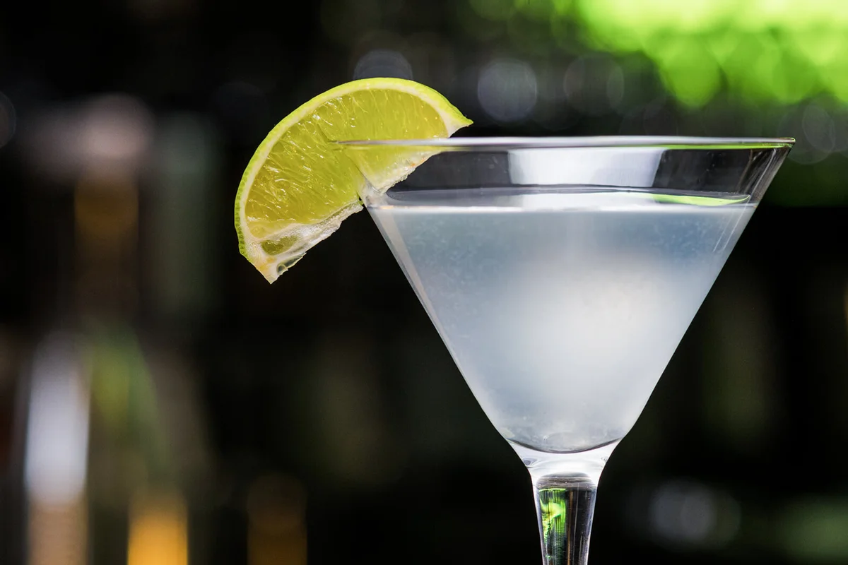 Transparent glass with opaque cocktail and lime slice