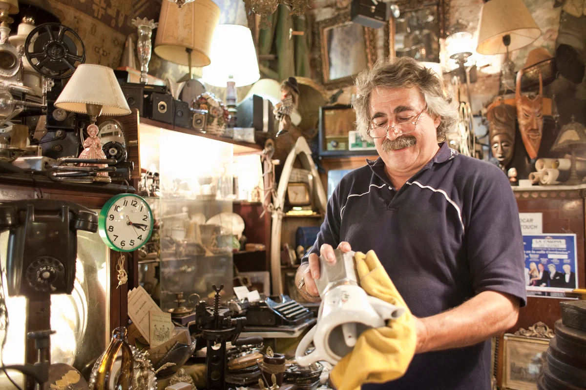 antique store owner polishing old coffee maker
