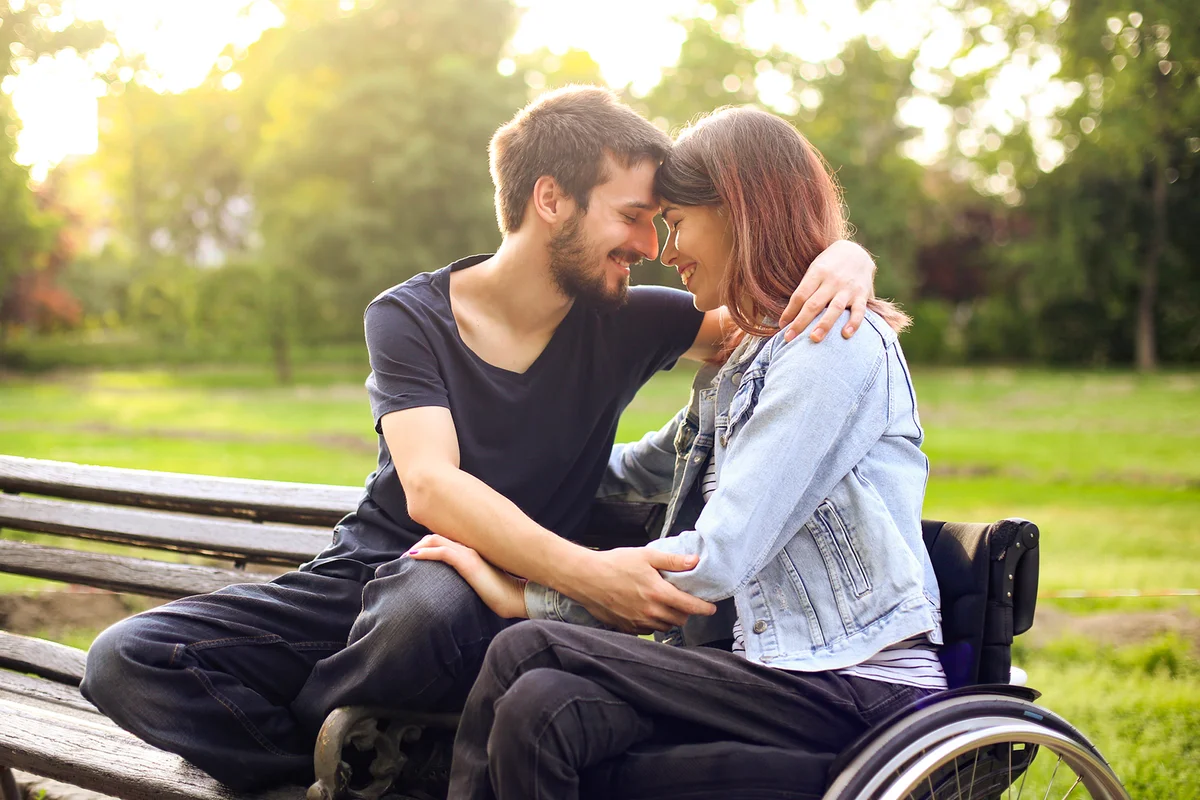 Young woman and her boyfriend embracing in a park
