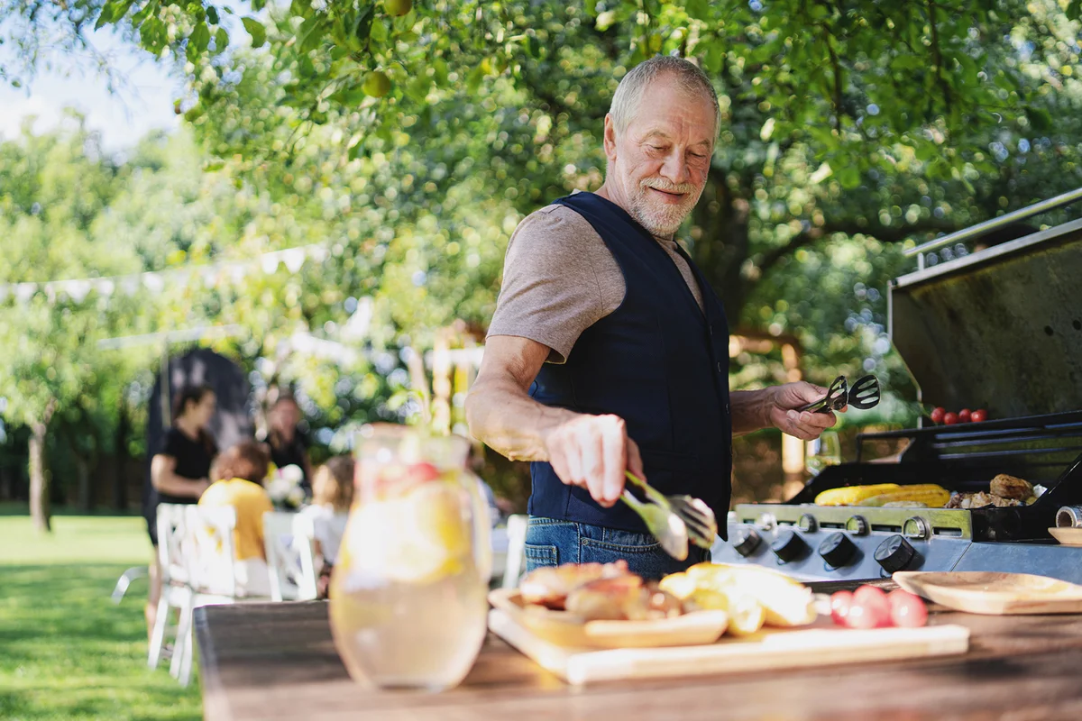 Senior man on outdoor summer barbecue garden party