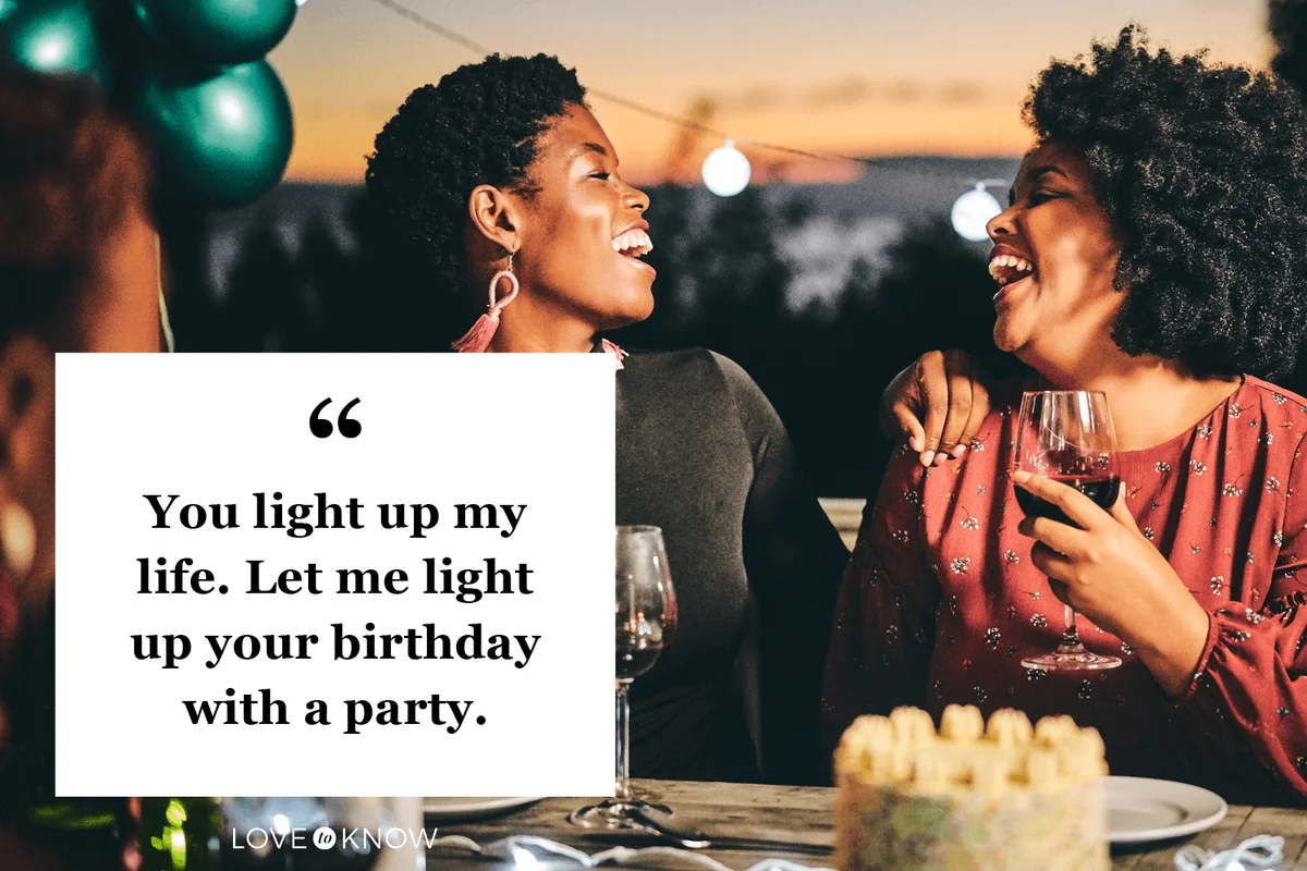 Cheerful female friends enjoying wine at birthday