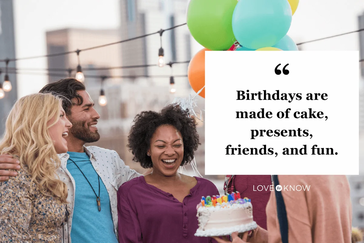 Friends celebrating birthday party on rooftop with birthday cake