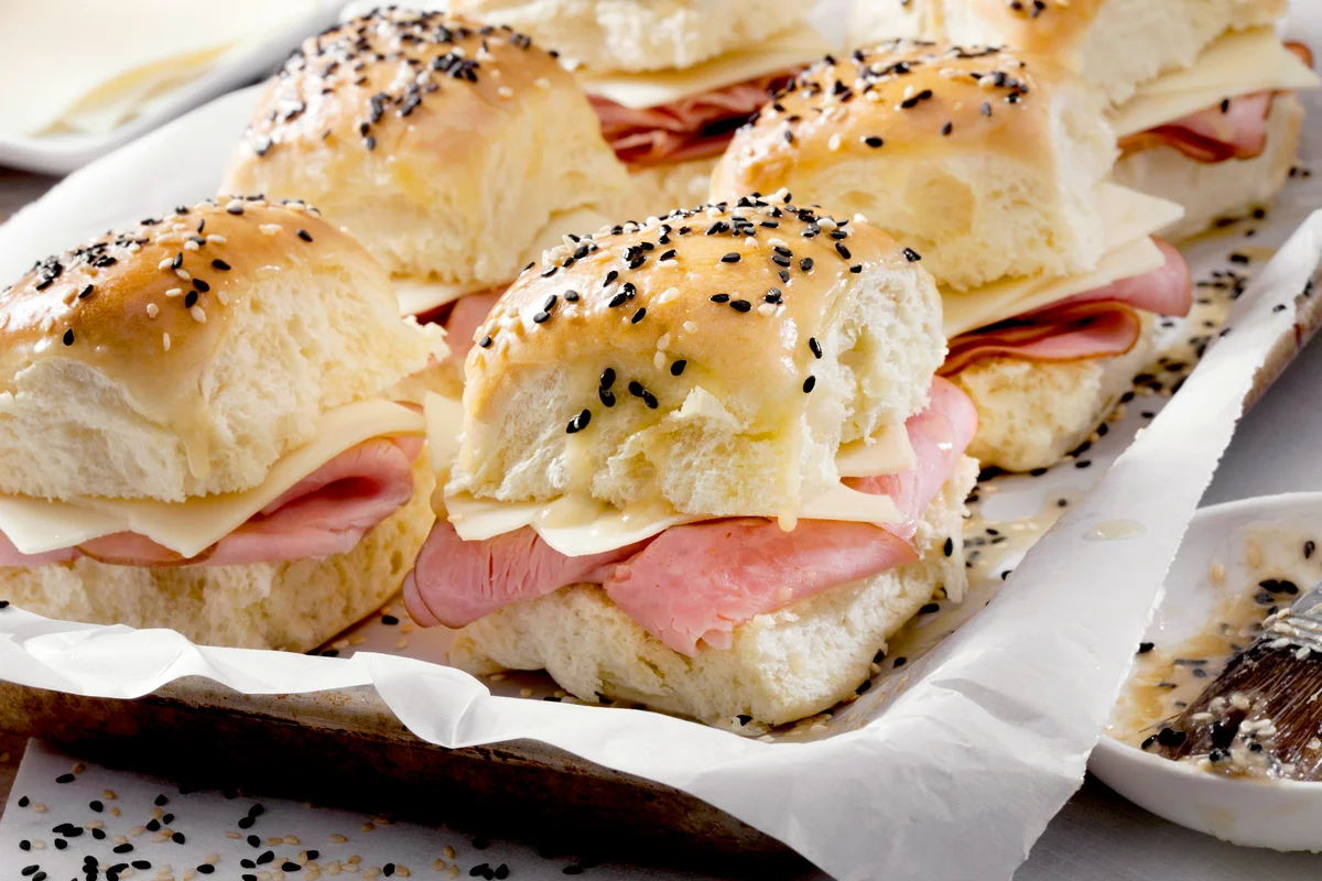 Preparing Ham And Swiss Sliders on White Tray Buns