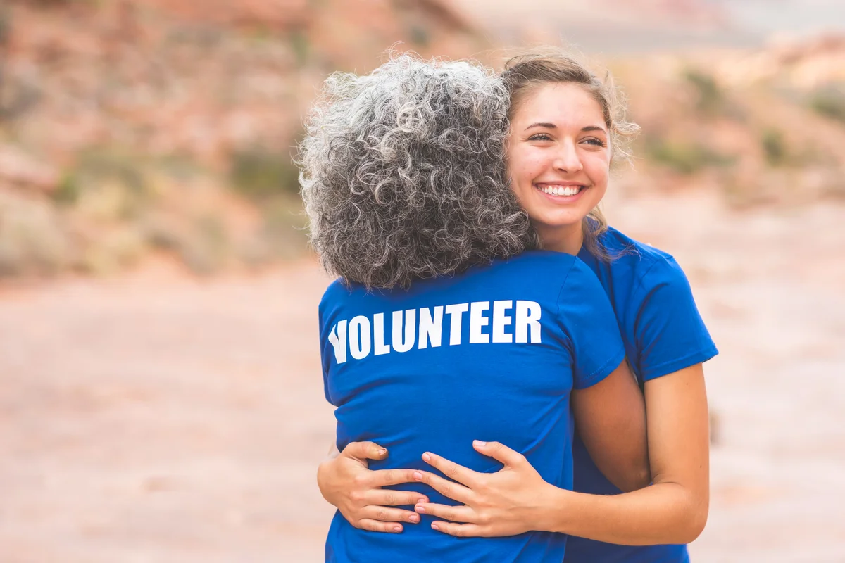 Two volunteers give each a hug before the big event