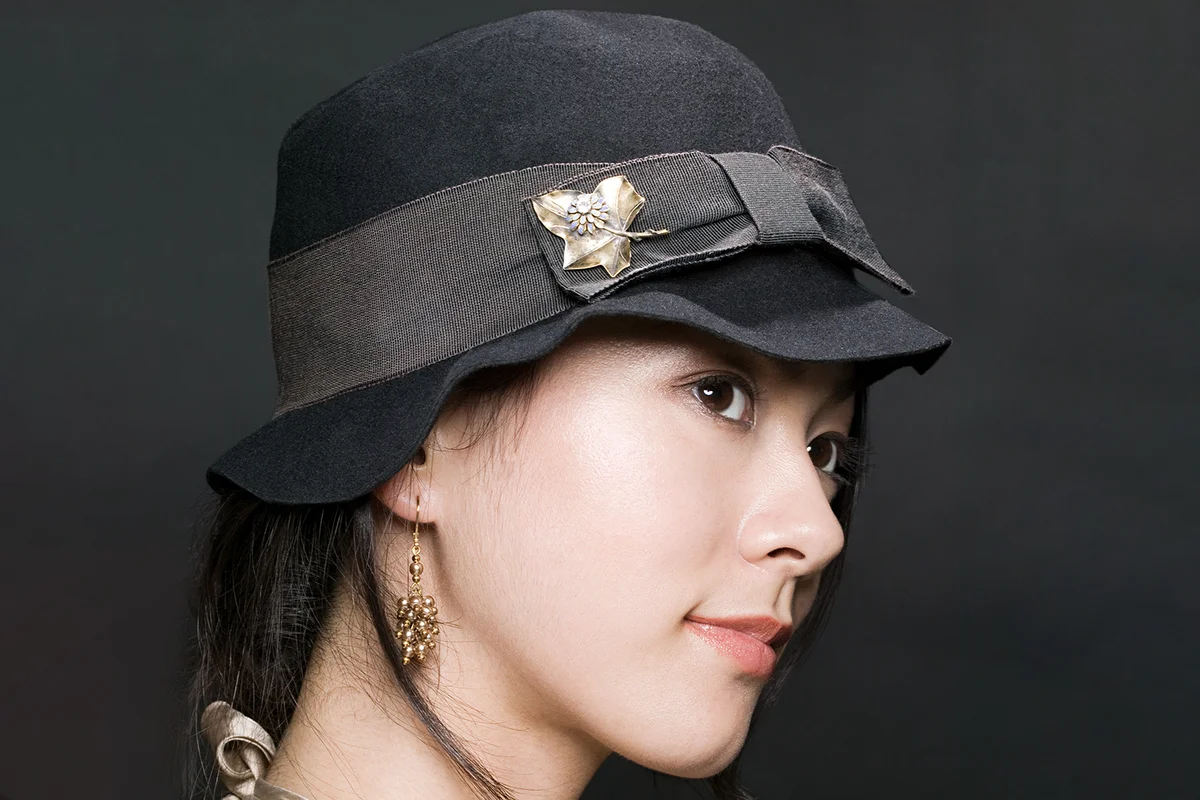 Young woman wearing a hat with a pinhat