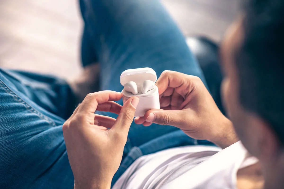 Wireless white headphones in the hands of a guy