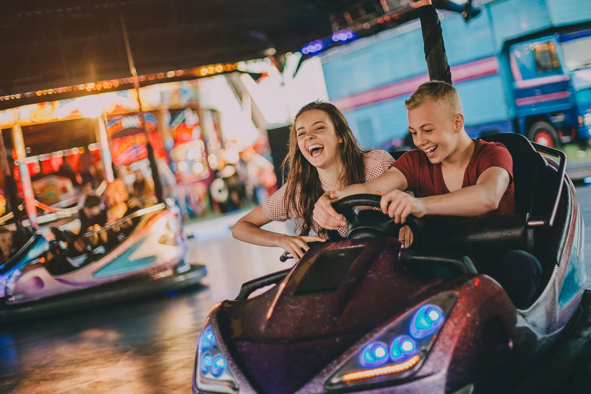 teenagers date amusement park in bumper cars