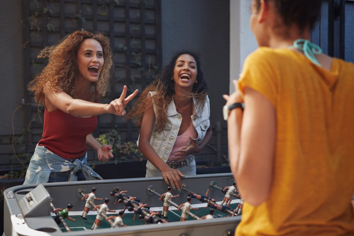 teenage girls playing foosball
