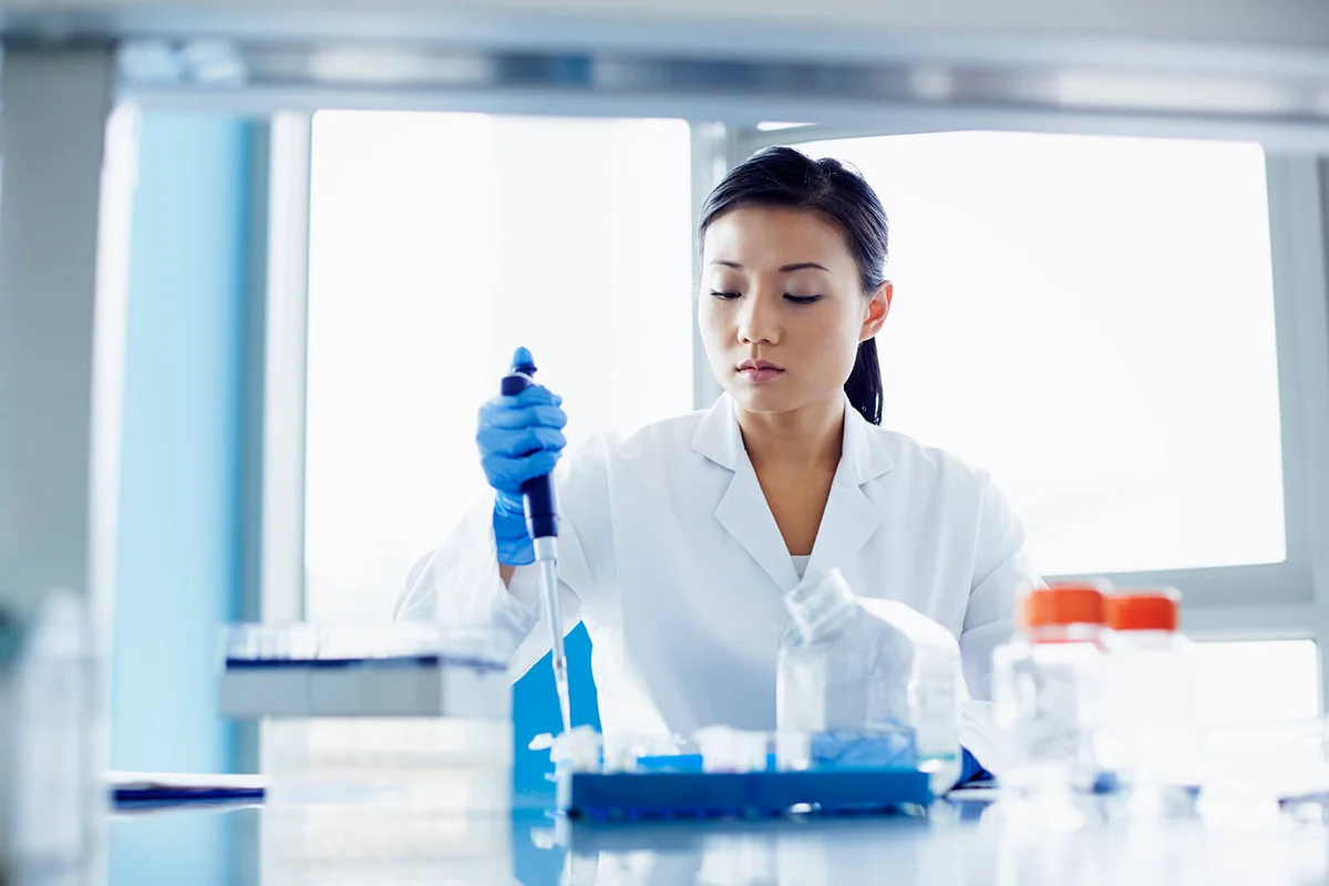 Scientist using pipette in research laboratory