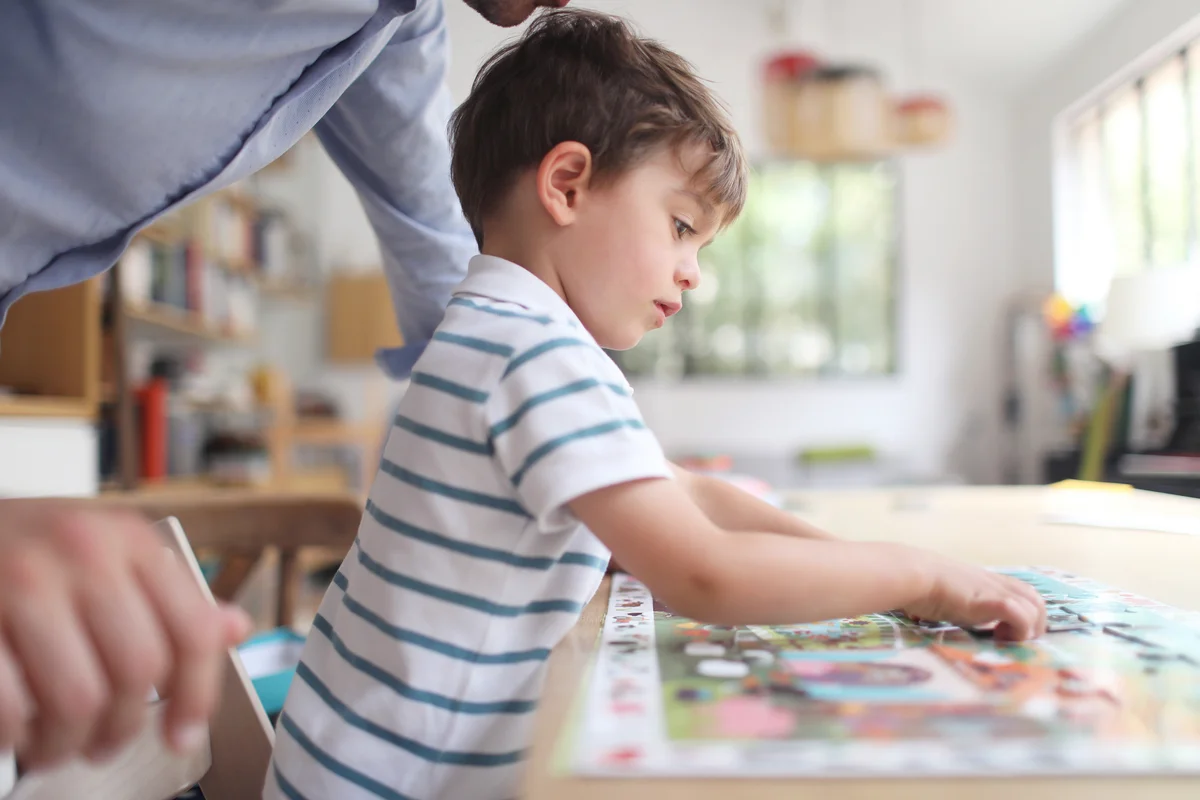 Boy making a puzzle with his dad