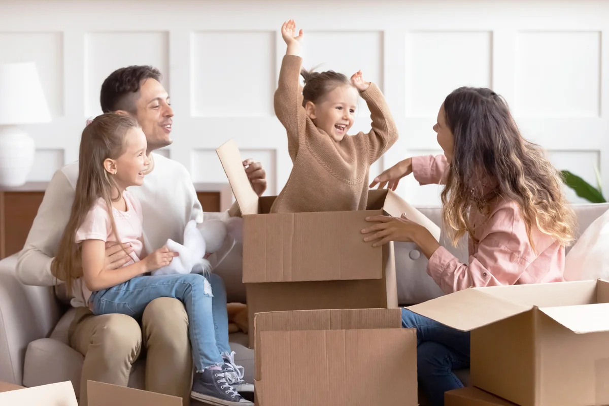 Happy parents and children playing with boxes