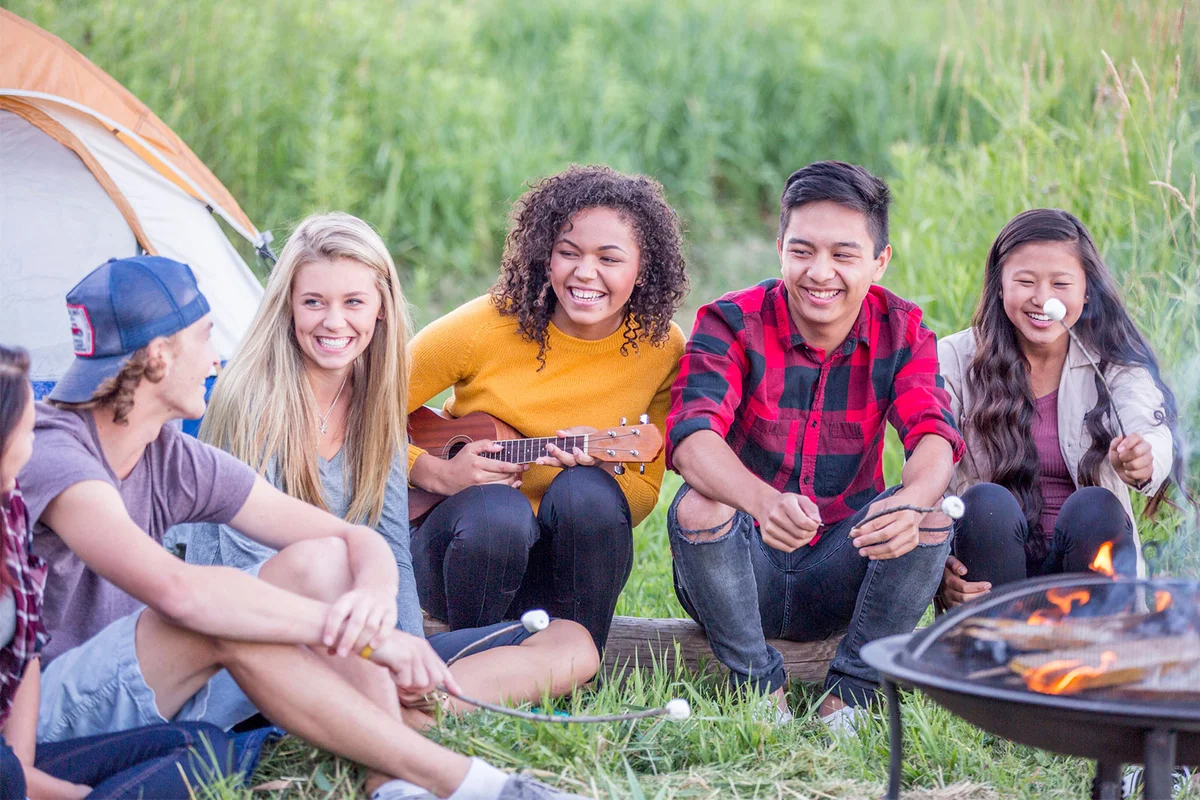 teenagers around campfire
