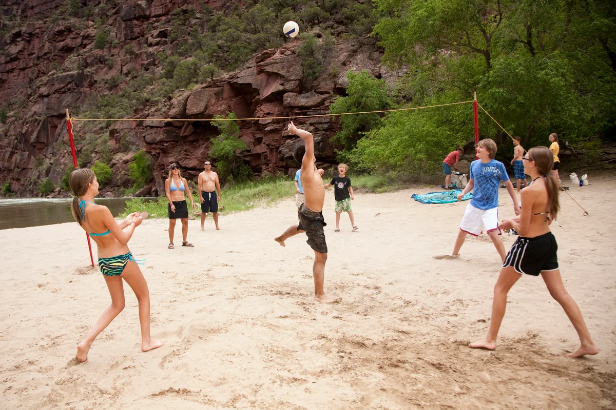 teenagers playing beach volleyball