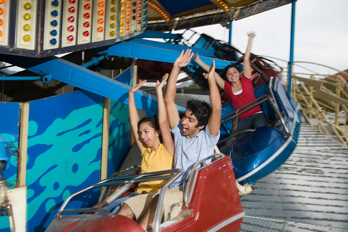teenagers on roller coaster at amusement park
