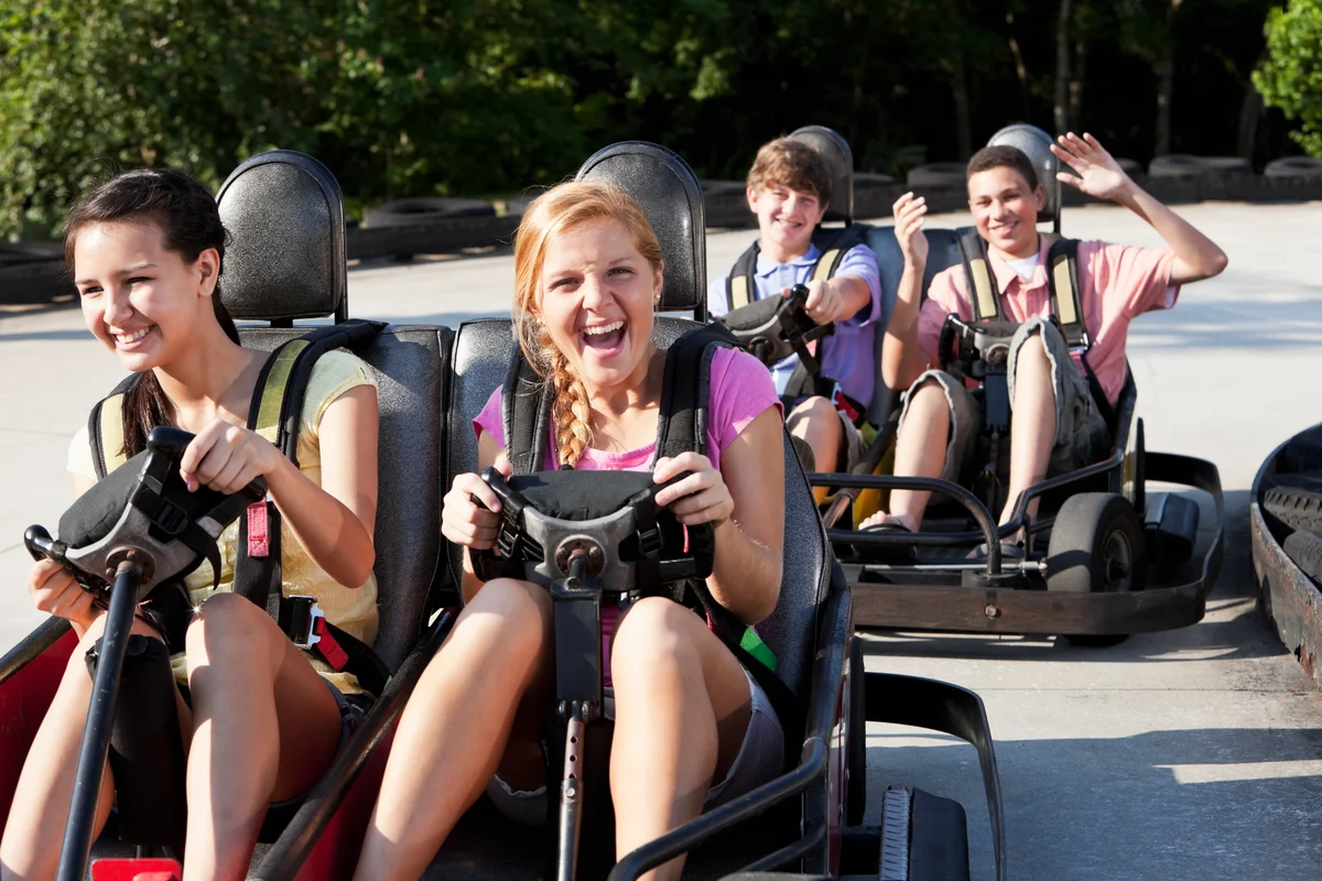 teenagers riding go karts