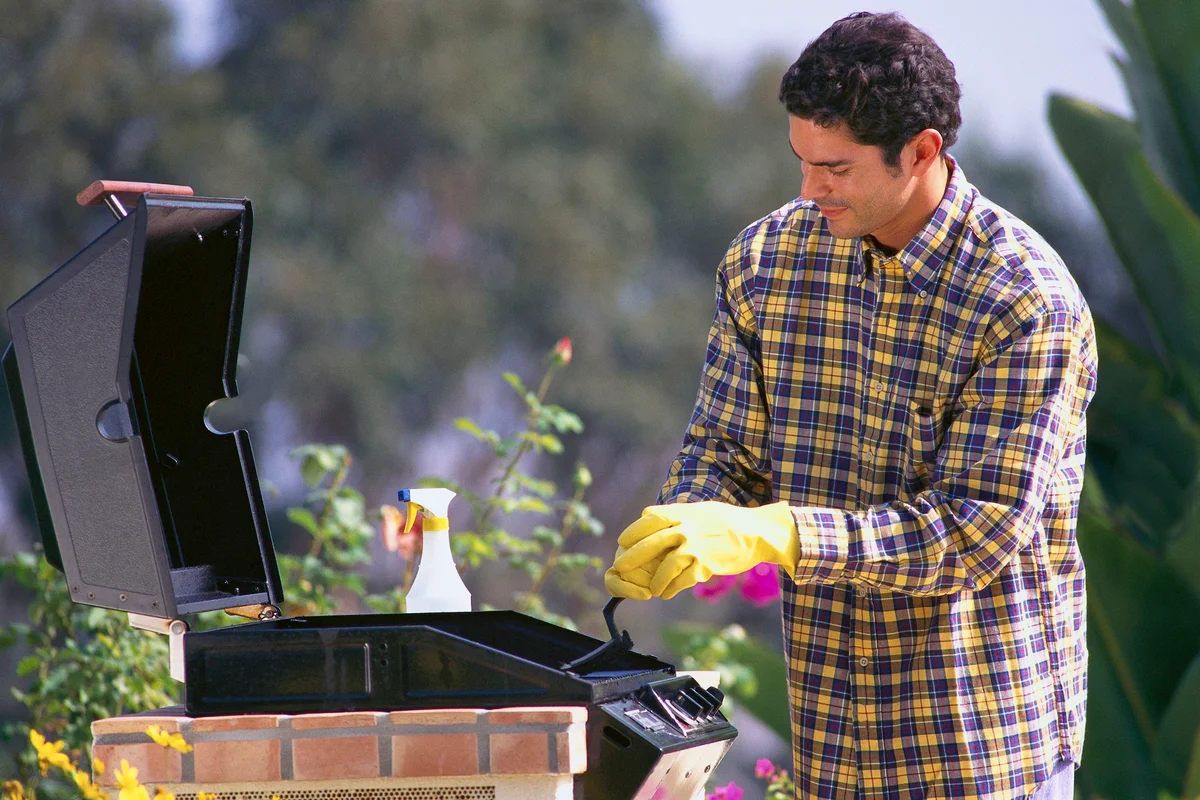 Man Cleaning Barbecue Grill