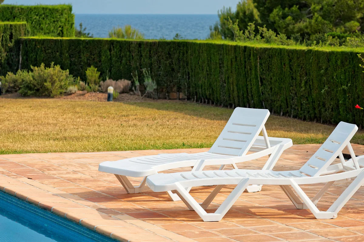 plastic lounge chairs by pool