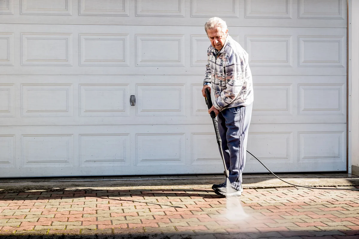 Active Senior Man Cleaning the Terrace with High Pressure