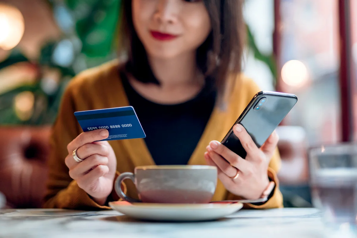 Woman Shopping Online On Smart Phone In A Cafe