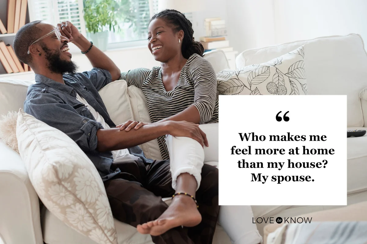 romantic couple on sofa at home laughing together