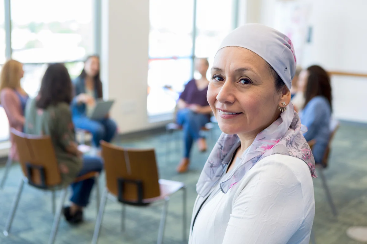 Cancer survivor with support group in background