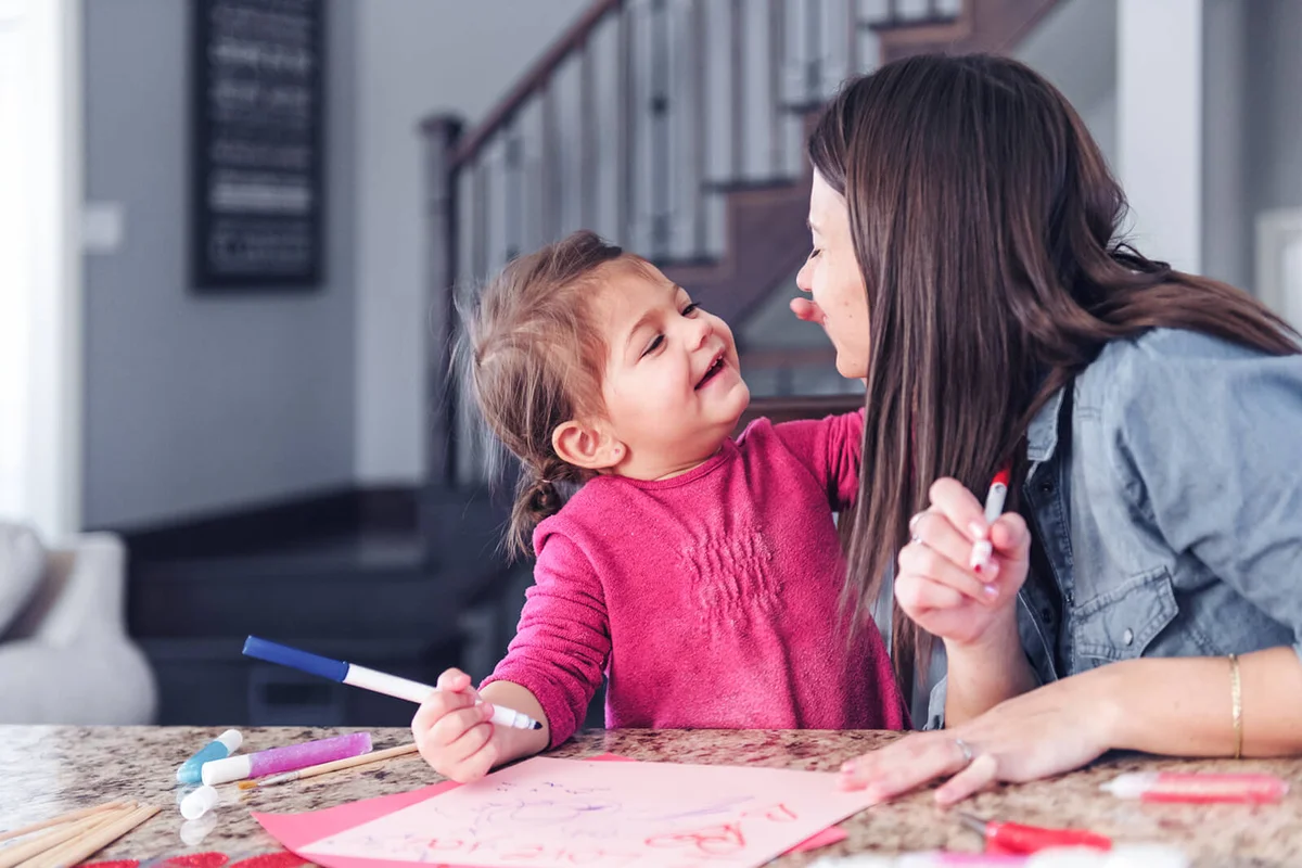 Mother making valentine cards with daughter