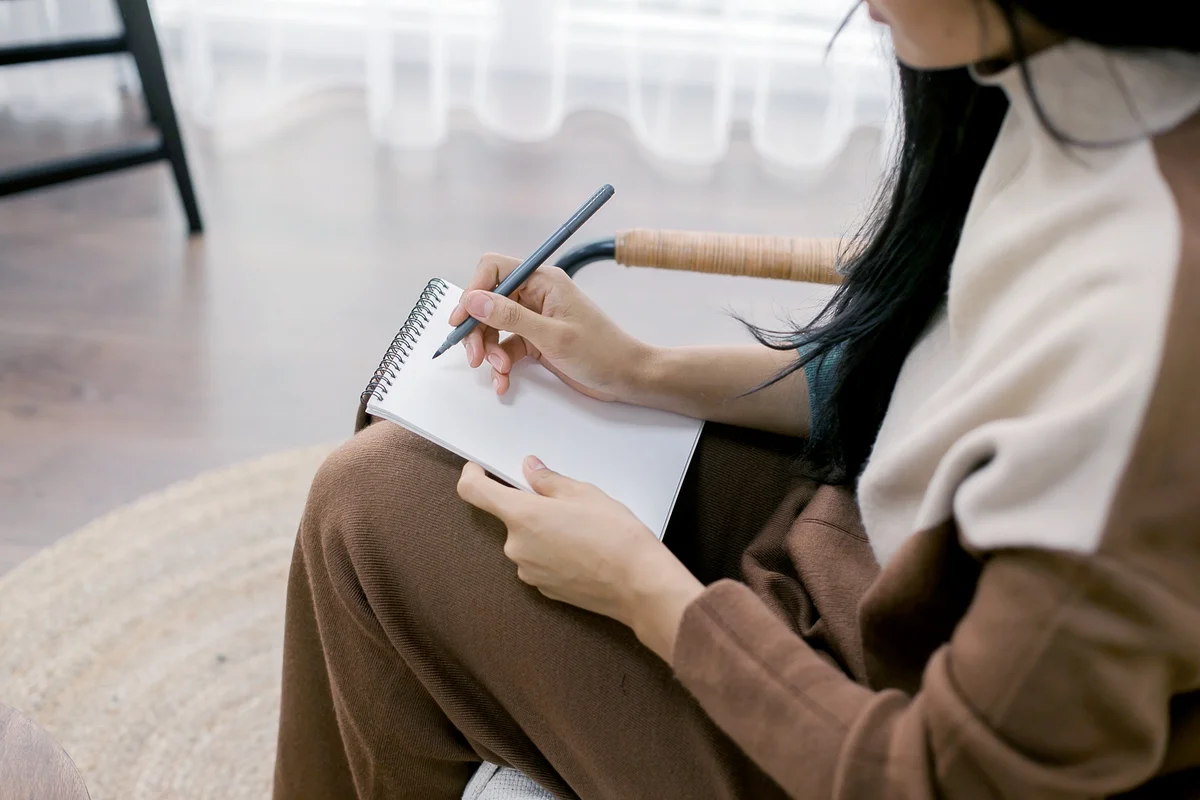 Woman writing on a notepad