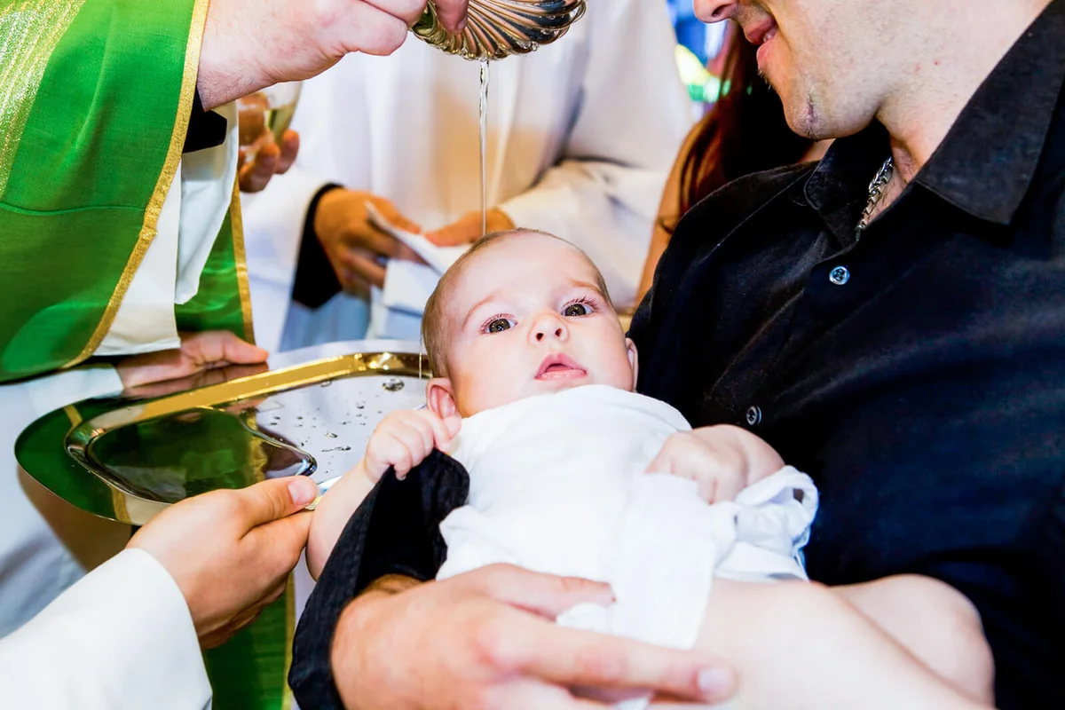 riest is baptizing little baby in a church