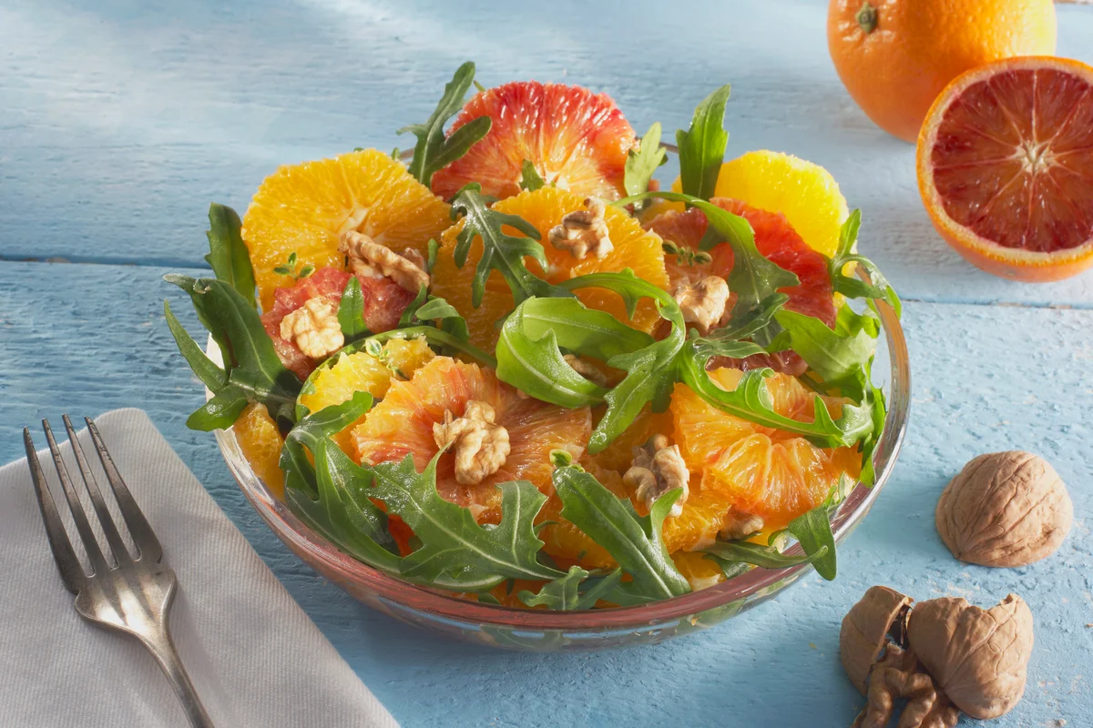 Orange and rocket salad in plate garnished with walnut