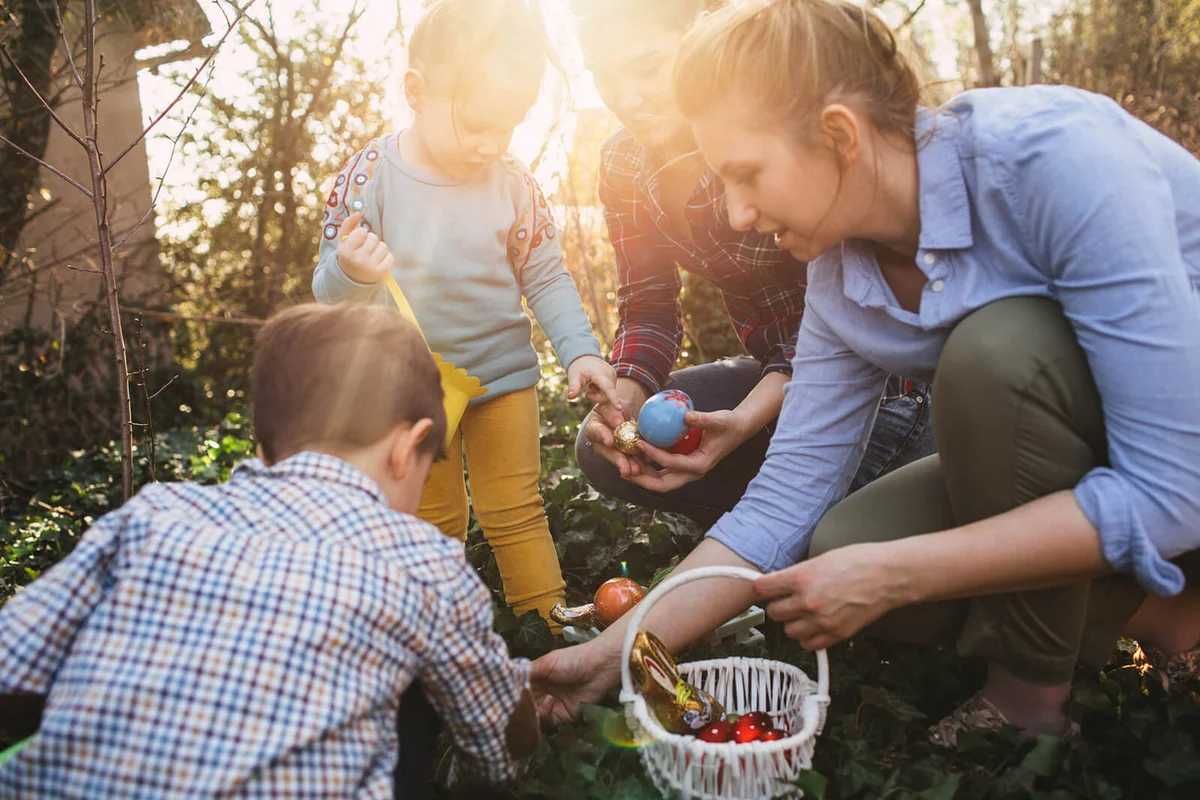 Cute little kids and their moms during Easter egg hunt