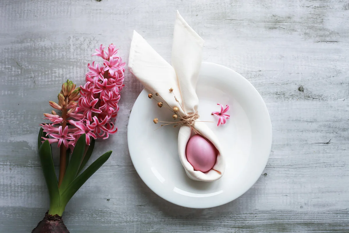 Easter pink egg, napkin in shape of bunny ears in plate