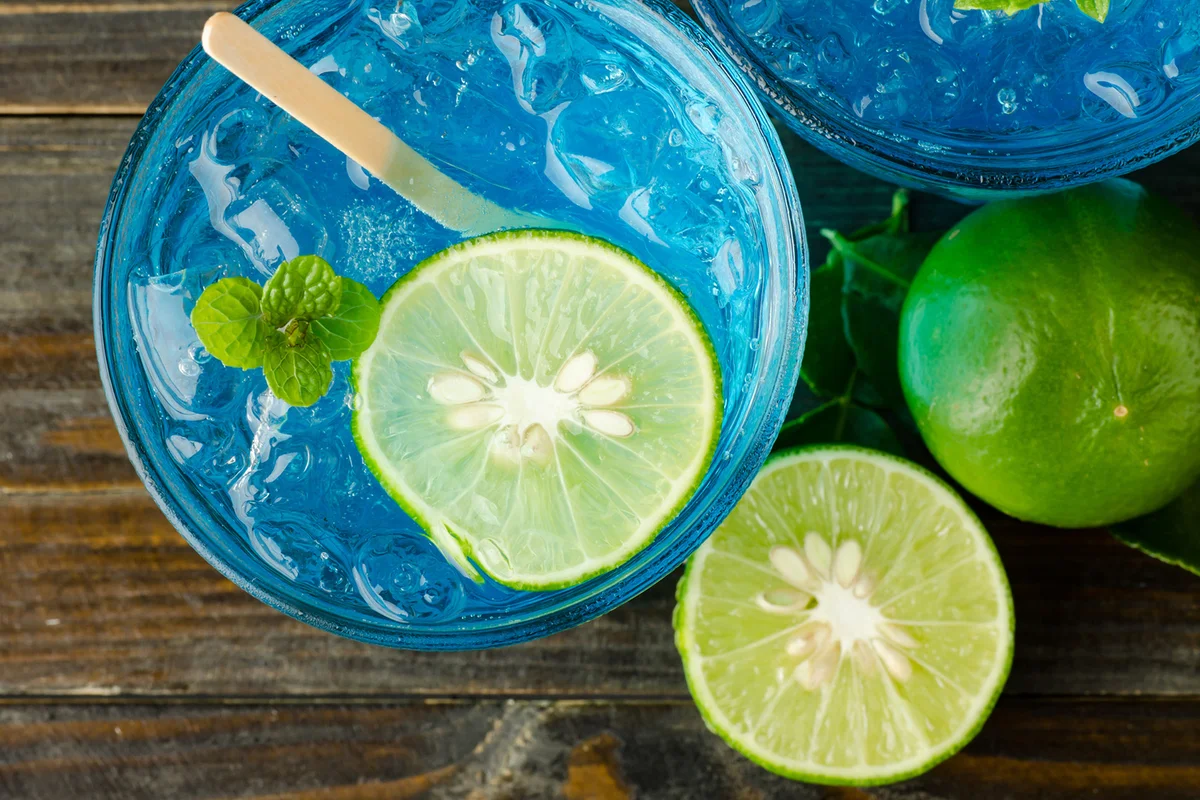 Bluejito Cocktail with lime on wooden background
