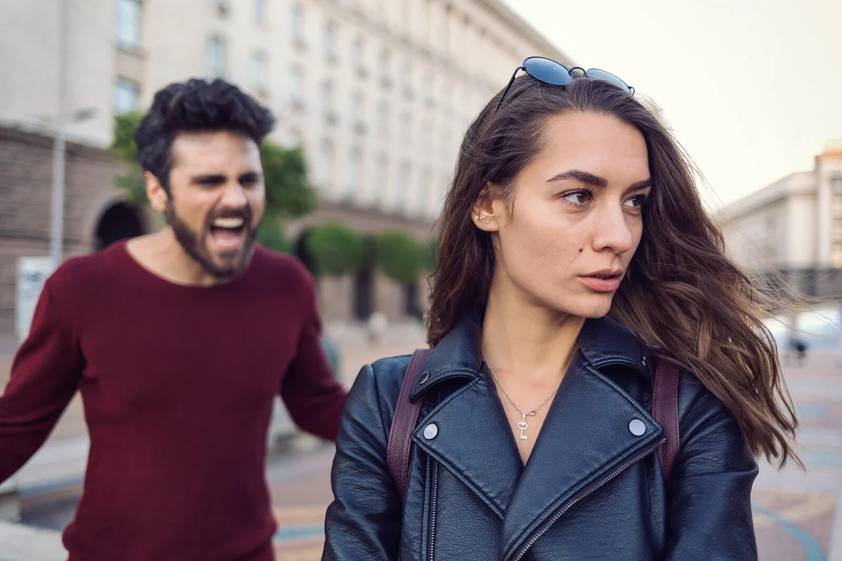 Man shouting at a woman outside at the street