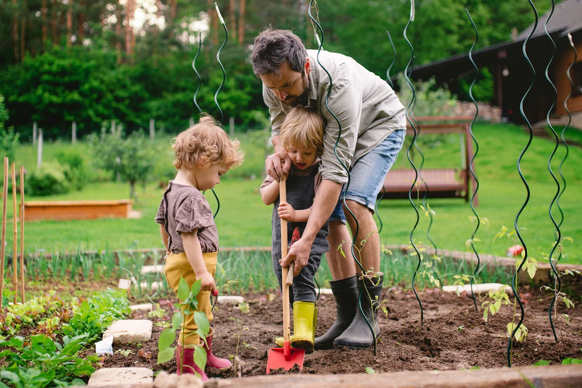 family planting garden in yard