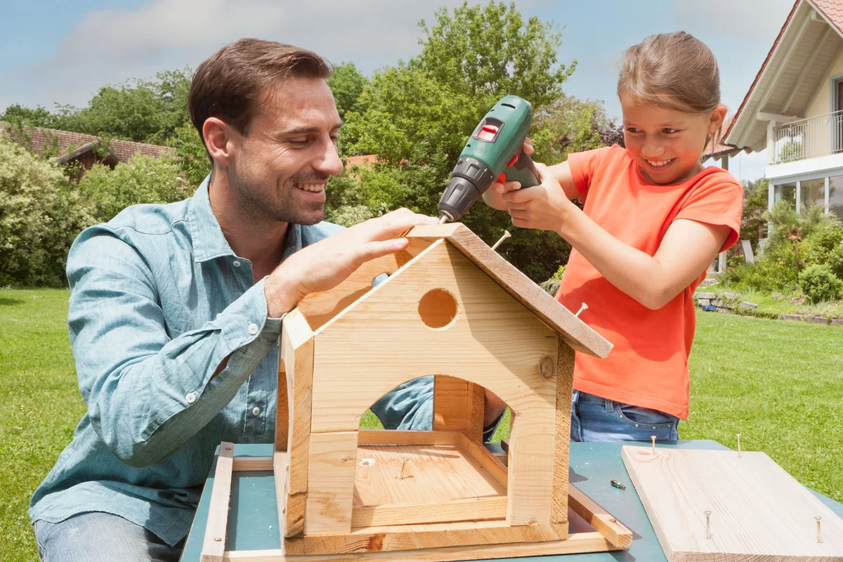 father and daughter building birdhouse