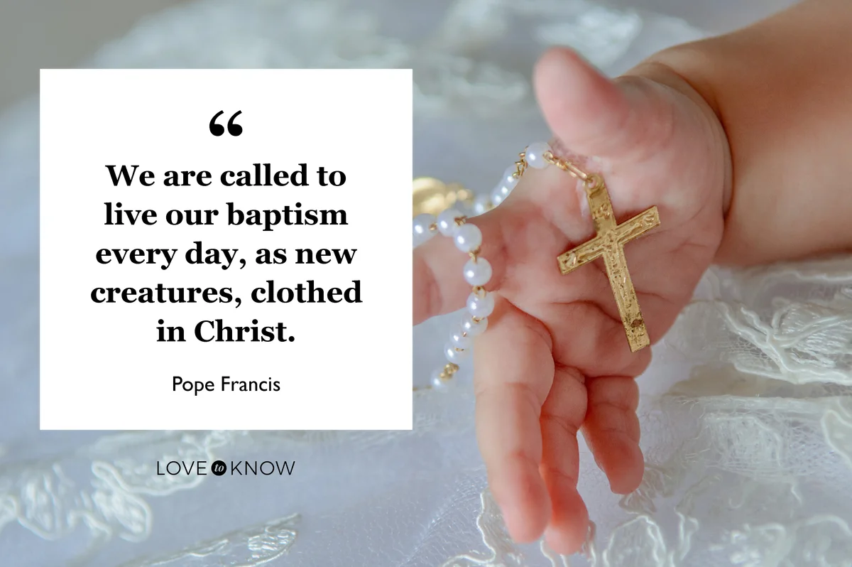 Child's hand with a crucifix on a white cloth background