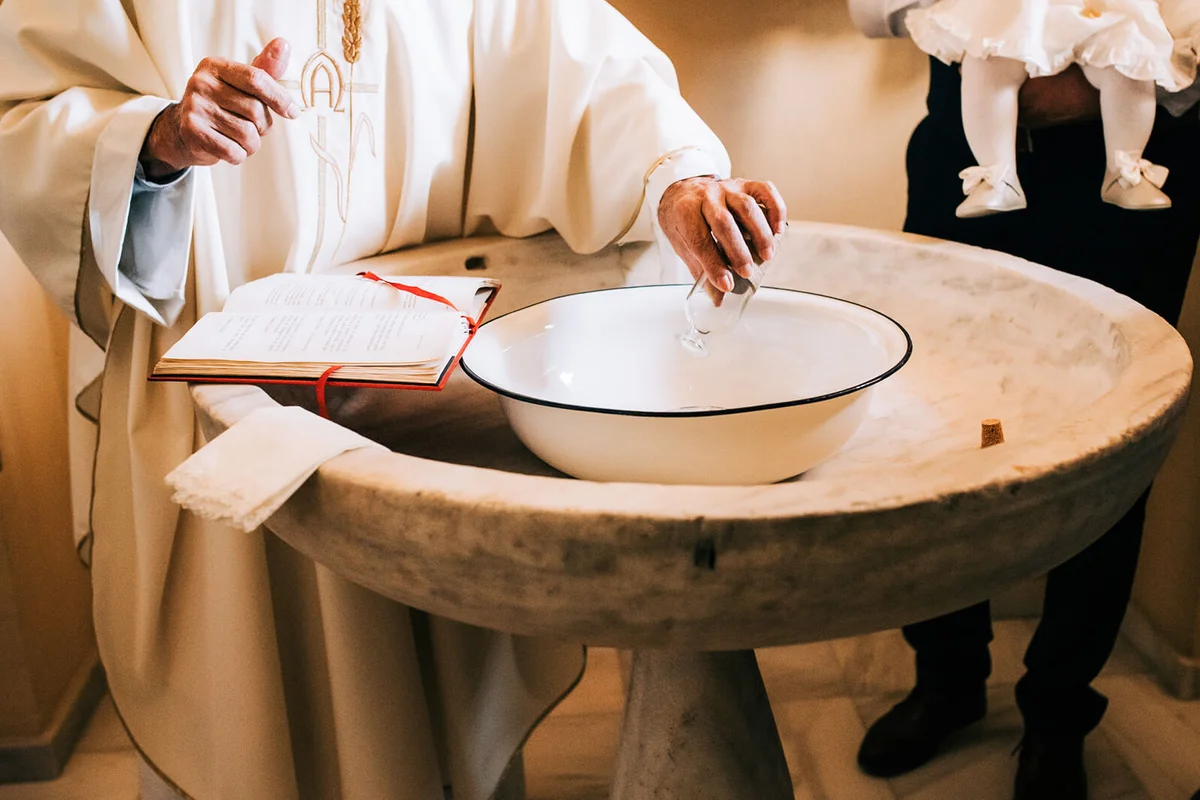 A priest during the process of baptizing a baby in the church
