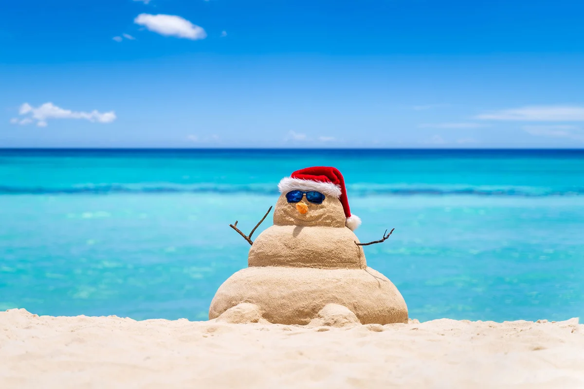 beach sand snowman with Santa hat sunglasses