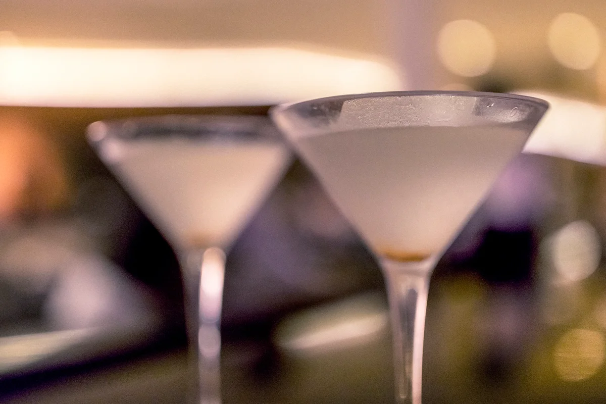 Two dirty martinis on a bar counter