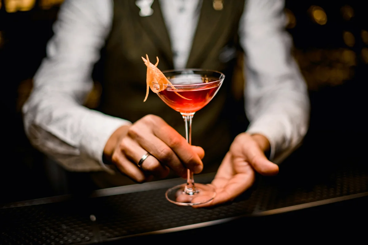 Fancy cocktail in hands of male bartender