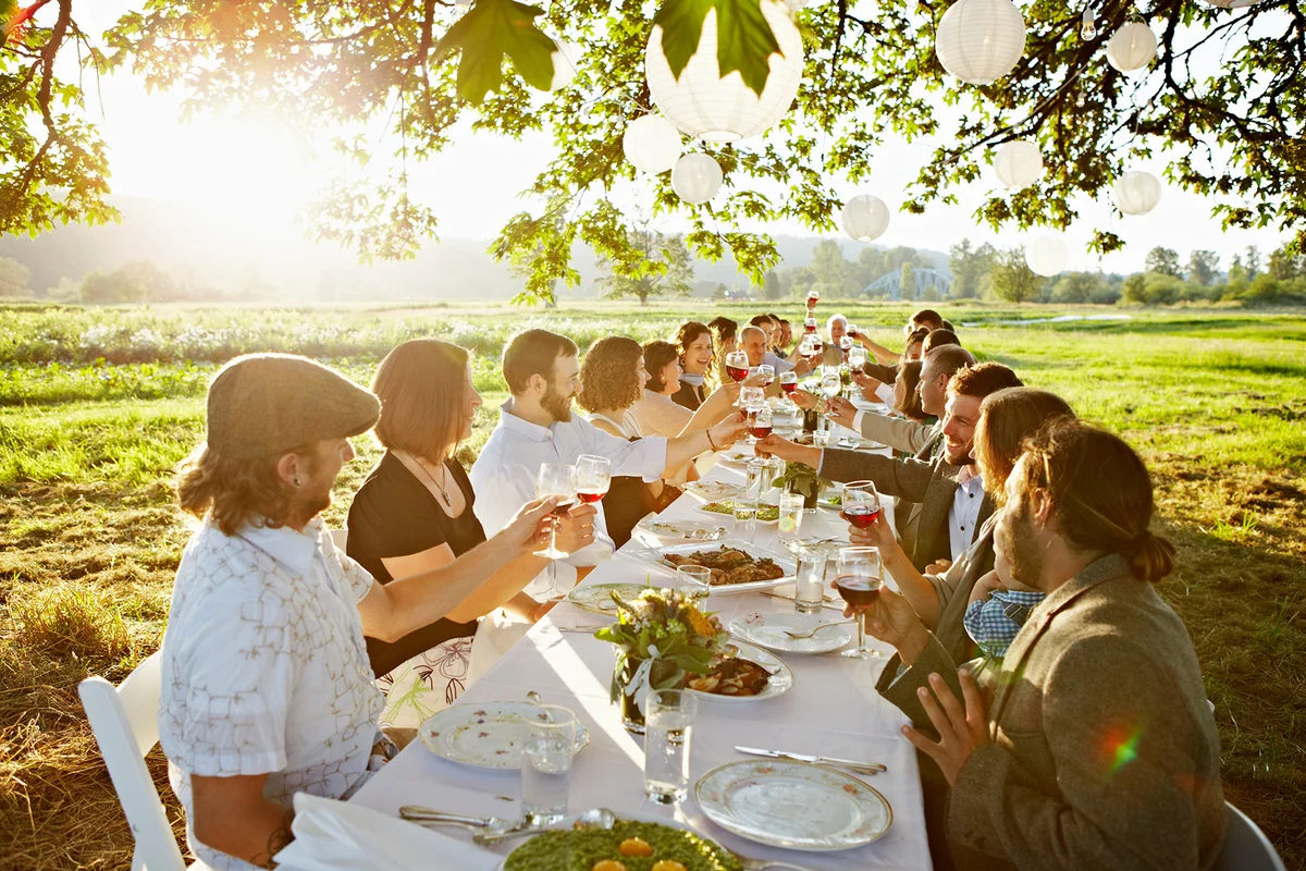 Group toasting with wine outside in field