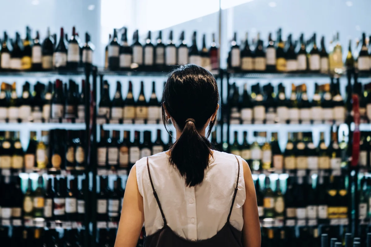 Young woman at grocery shopping for wines