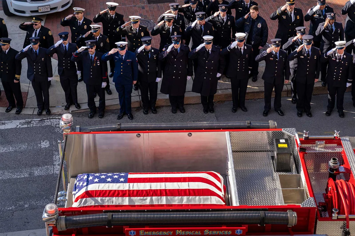 Firefighters salute at funeral procession