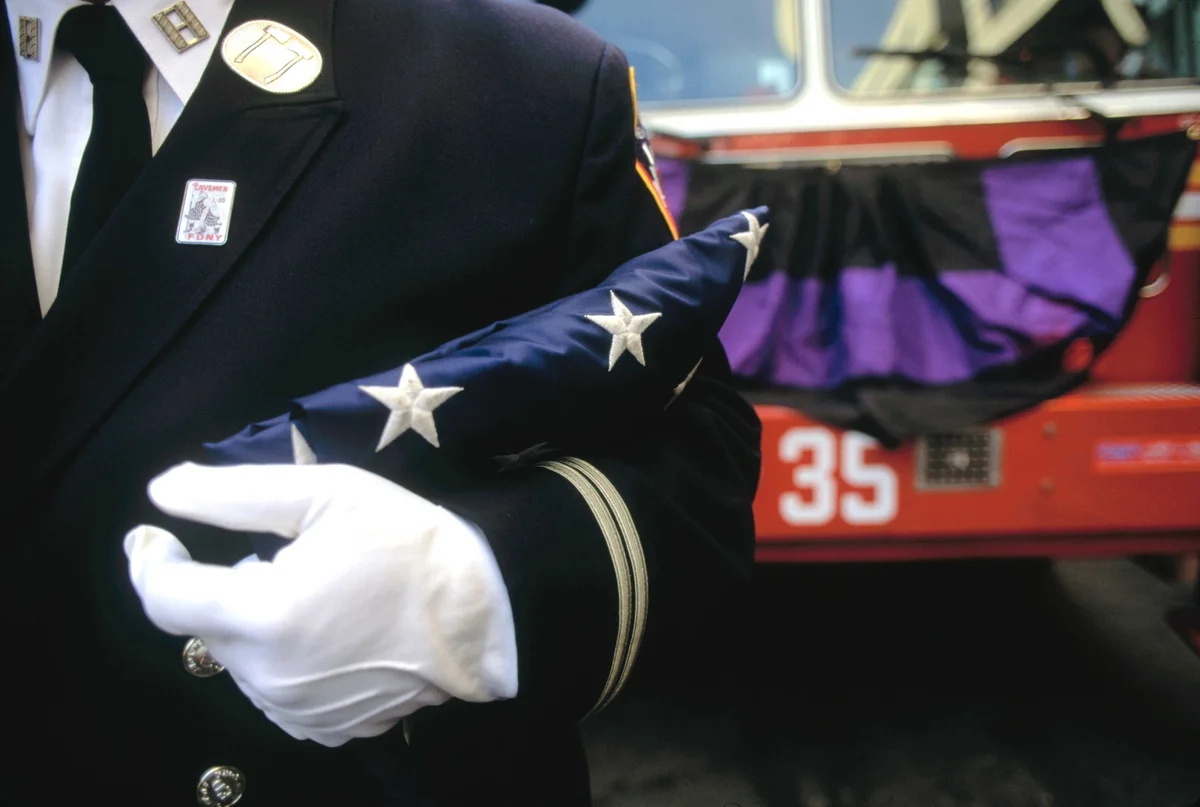 Holding Folded American Flag at Fireman's Funeral