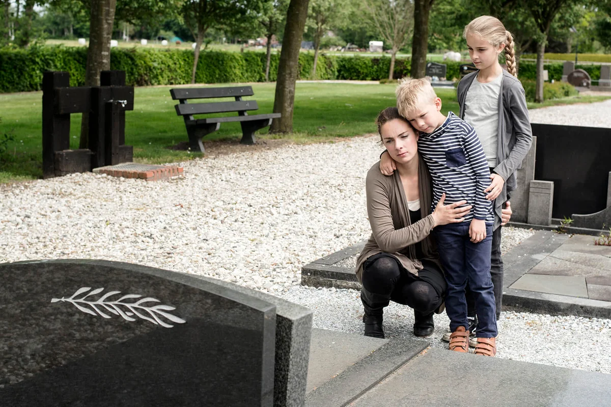 Young family visiting grave of family